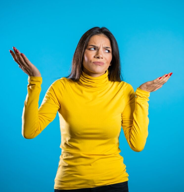 latin woman with hands in the air, looking confused