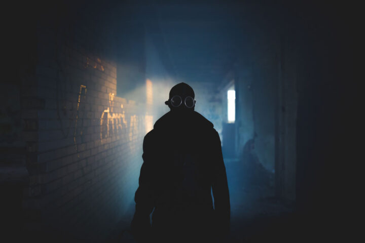 Silhouette of a masked man in dark and scary corridor