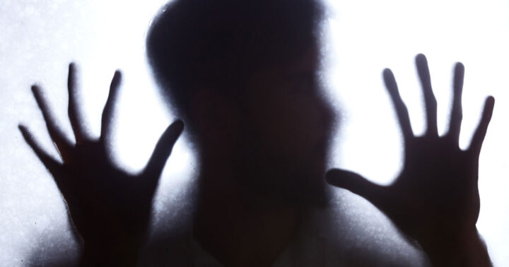 Sinister silhouette of a head and hands