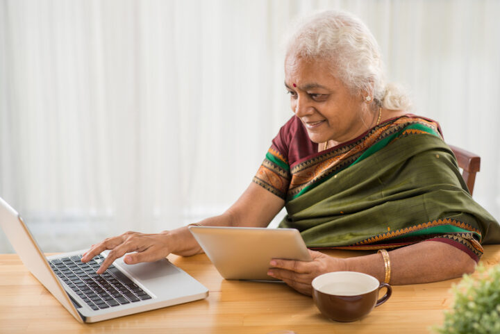 elderly Indian woman using a computer and a tablet