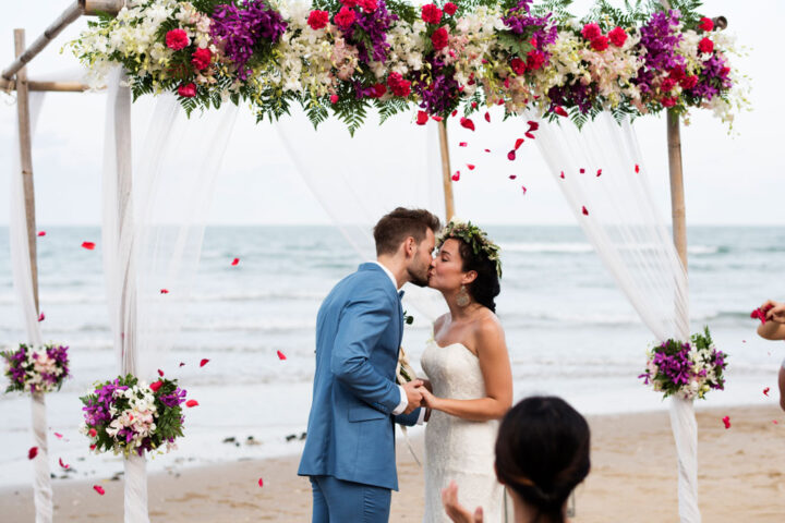 Bride and groom kissing at the end of the ceremony, on the beach