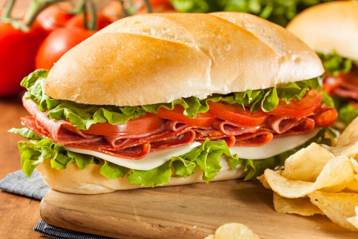 Italian sandwich filled with salad, salami, cheese and tomatoes
