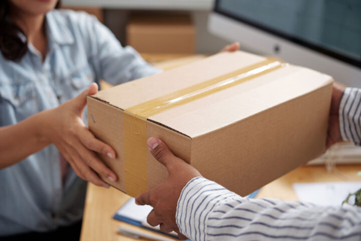 close-up on a parcel being given by a woman to another person