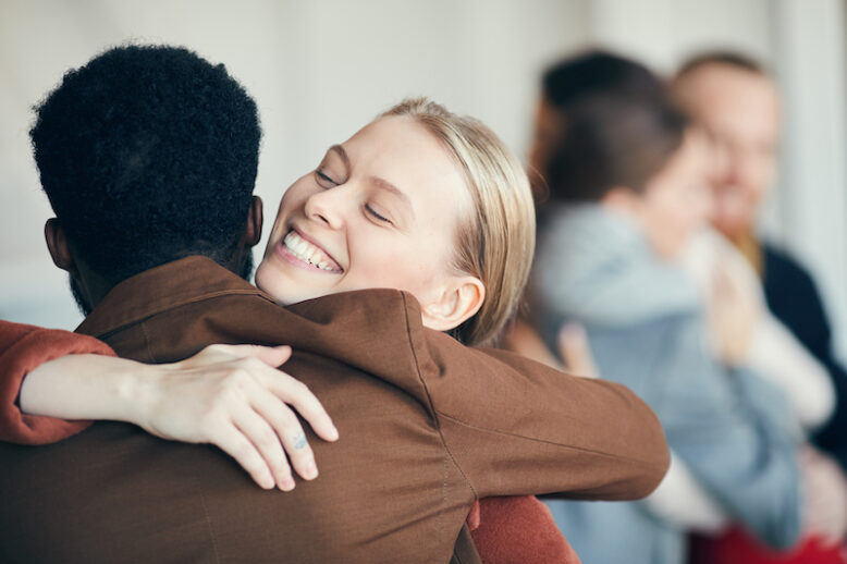 Portrait of smiling young woman hugging friend