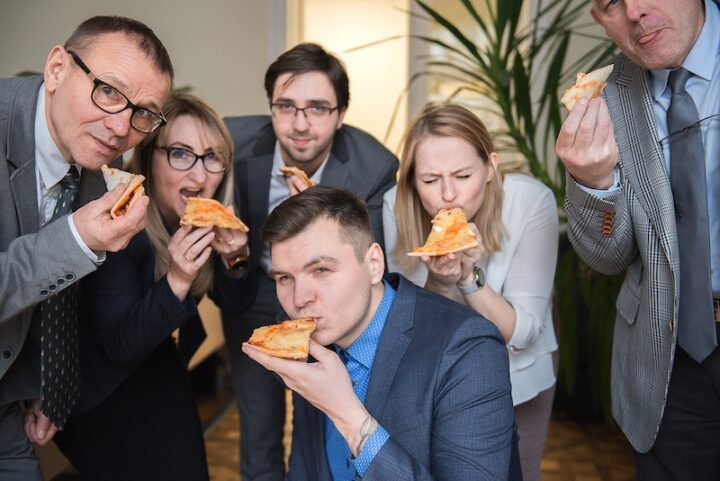  happy business team eating pizza in office