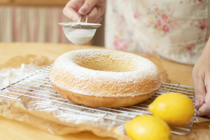 ring-shaped cake with flour and two lemons on the side