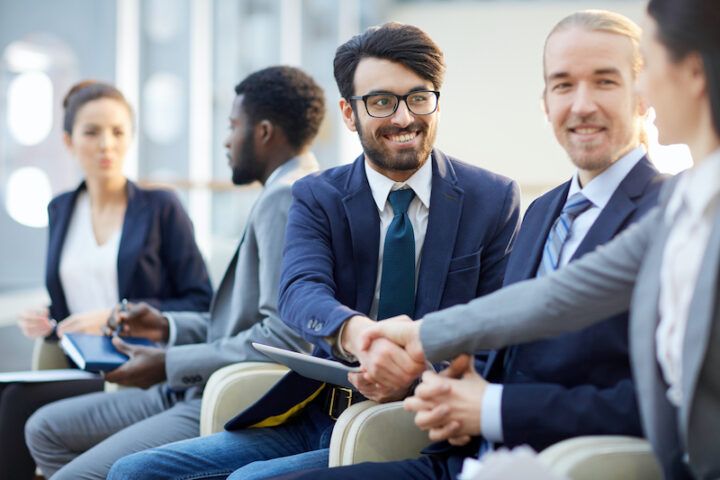 Two colleagues handshaking after business conference
