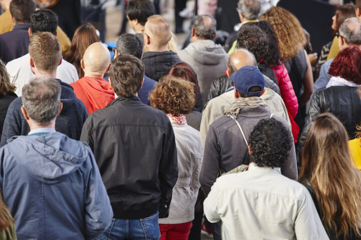 Group of people listening on the street. Urban crowded background.