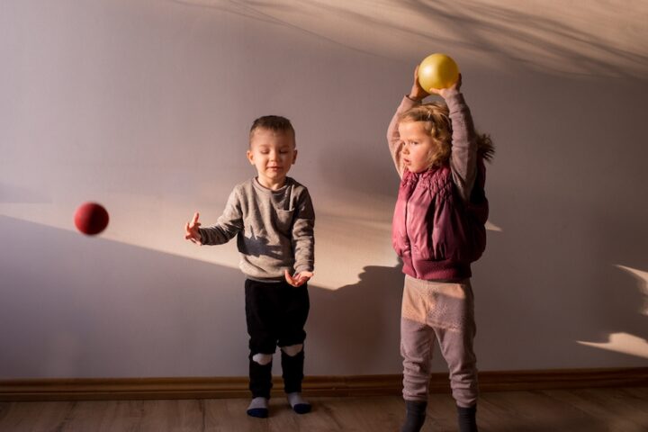 Two children playing with balls