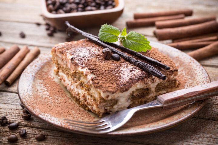 Tiramisu in the plate on the wooden background