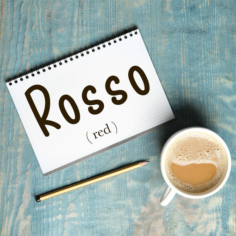 cover image with the word “rosso” and its translation written on a notepad next to a cup of cofee