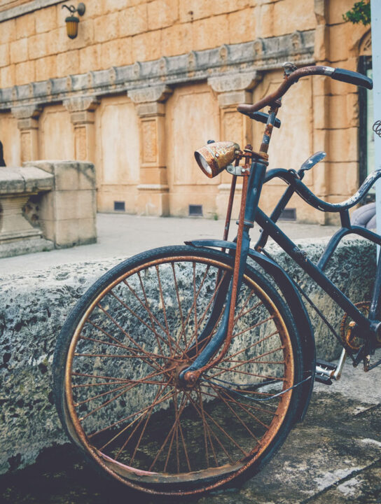 Old rusted bicycle standing at the street  