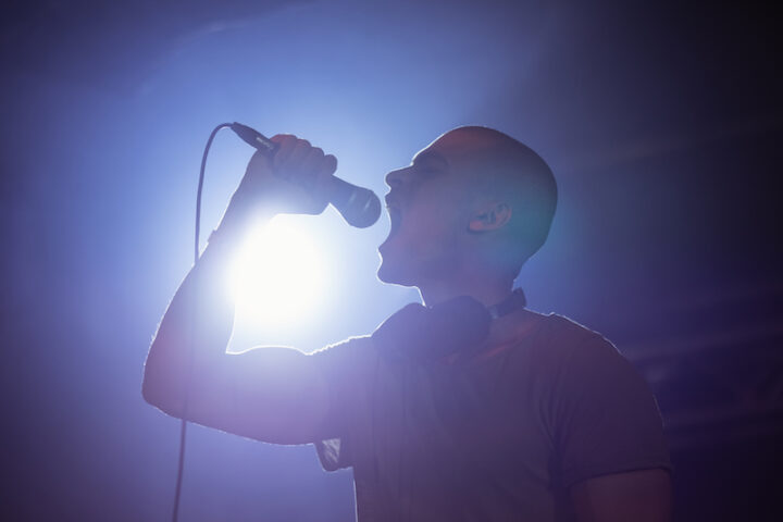 Cheerful male singer performing at nightclub during music festival