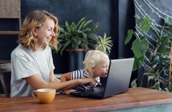young toddler kissing the laptop of his mummy