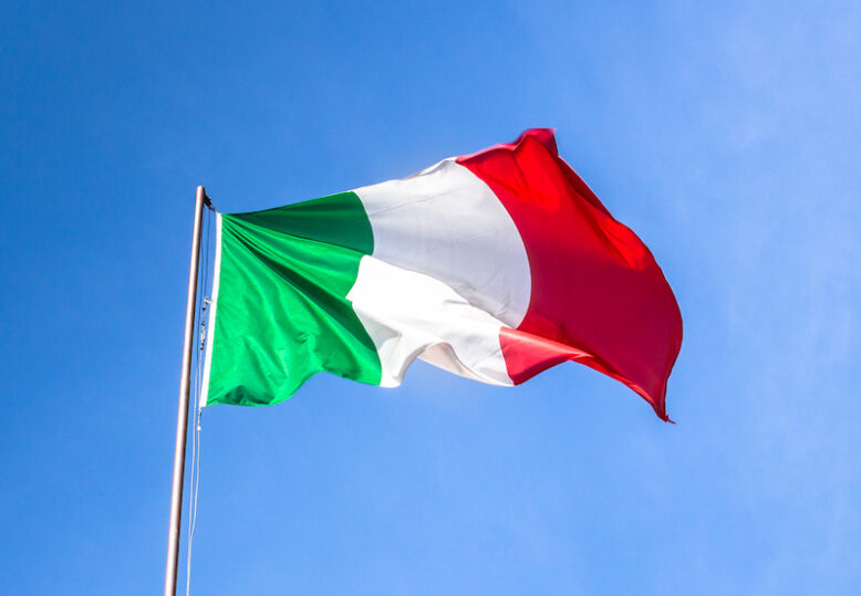 Waving Italian flag against blue sky