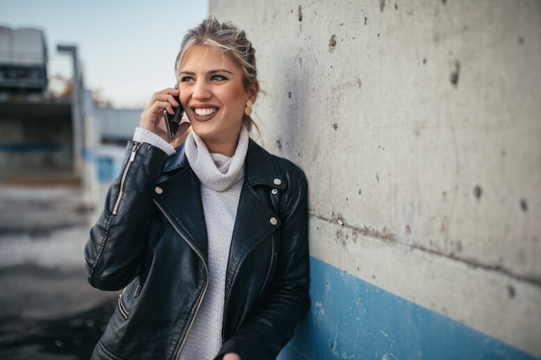 girl smiling and talking with her smartphone