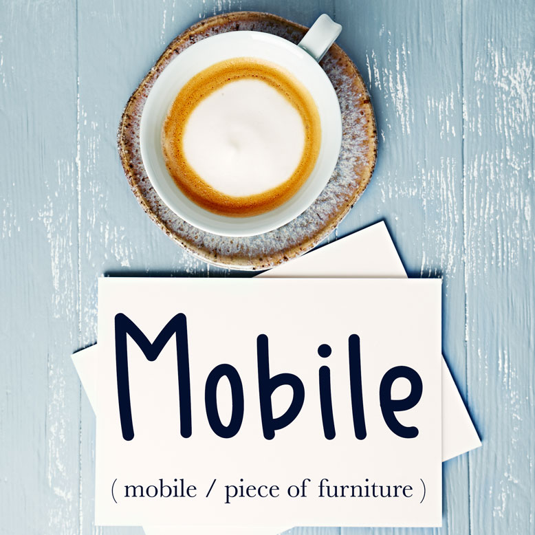 cover image with the word “mobile” and its translation written on a notepad next to a cup of coffee