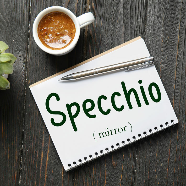 cover image with the word “specchio” and its translation written on a notepad next to a cup of coffee