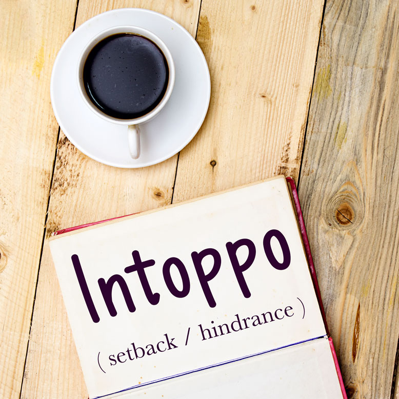 cover image with the word “intoppo” and its translation written on a notepad next to a cup of coffee