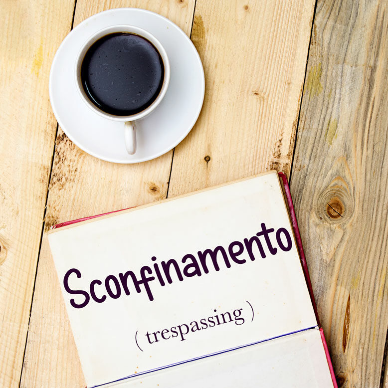 cover image with the word “sconfinamento” and its translation written on a notepad next to a cup of coffee
