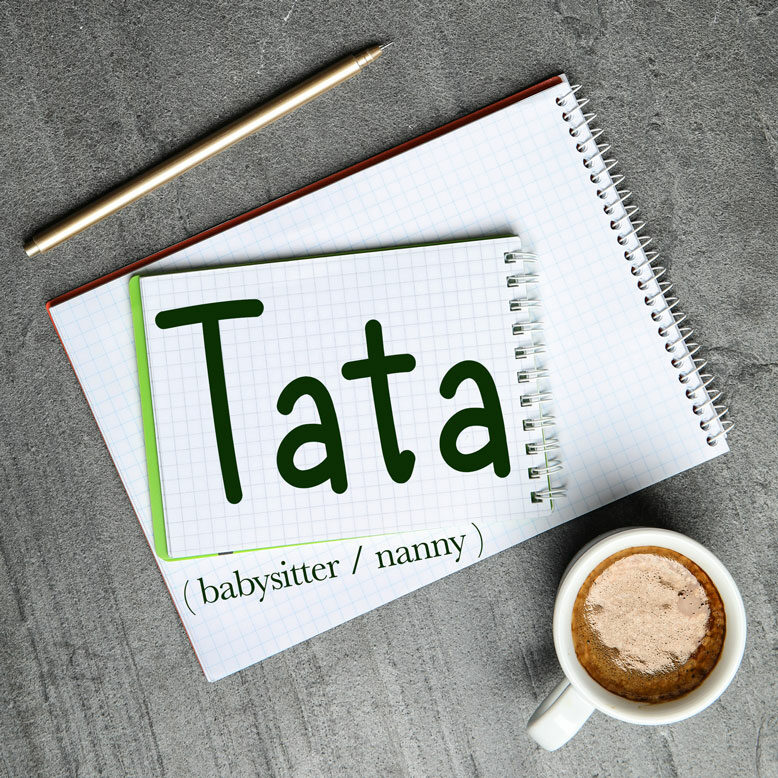 cover image with the word “tata” and its translation written on a notepad next to a cup of cofee