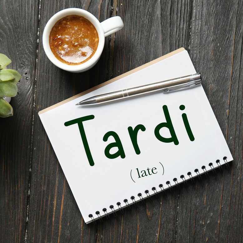 cover image with the word “tardi” and its translation written on a notepad next to a cup of coffee