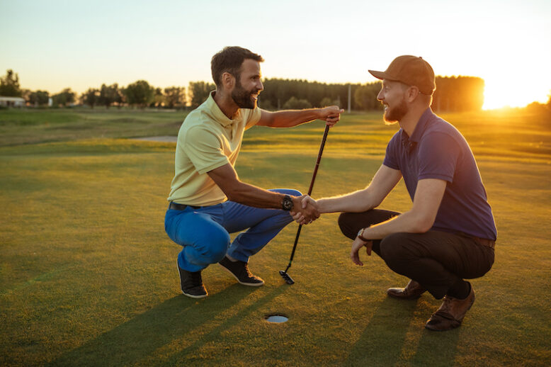 Two golfers shaking hands on the golf course.
