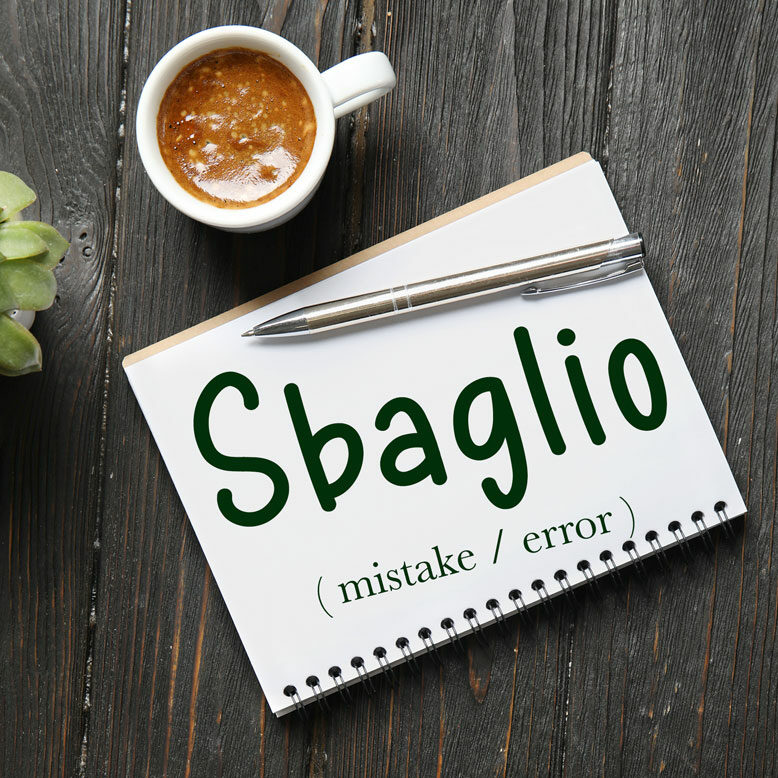 cover image with the word “sbaglio” and its translation written on a notepad next to a cup of coffee