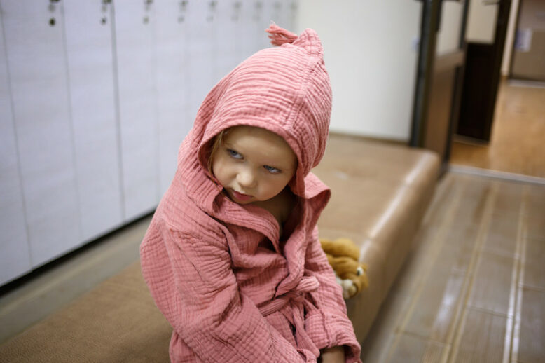 little girl after spa in a dressing gown in a dressing room.