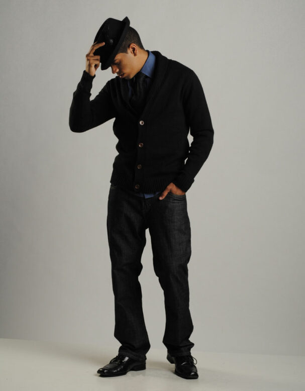 man posing with dark fashionable clothes in a photography studio
