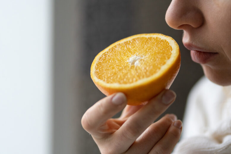 Woman smelling an orange