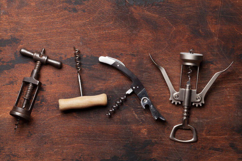 Various wine corkscrews on wooden table.