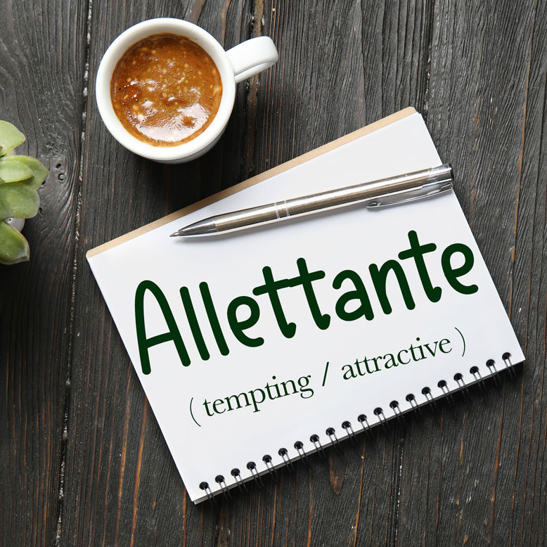 cover image with the word “allettante” and its translation written on a notepad next to a cup of coffee