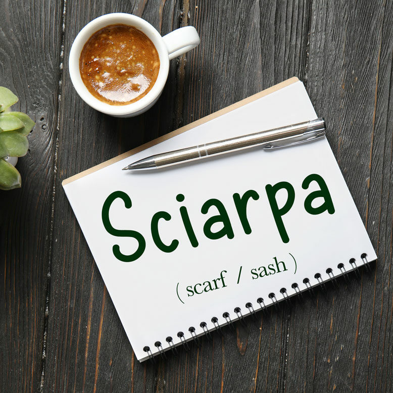 cover image with the word “sciarpa” and its translation written on a notepad next to a cup of coffee