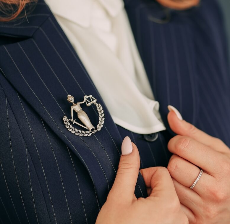 A woman in a blue blazer wearing a brooch