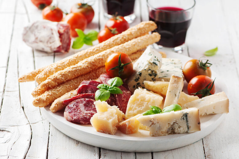 Concept of italian antipasto with cheese and sausage, selective focus