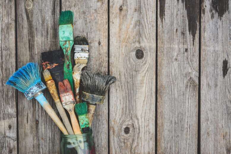 Old dry paint brush on wooden background