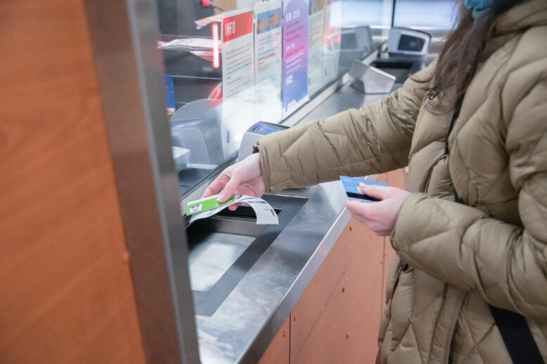 woman buys a subway ticket at the ticket office at the station