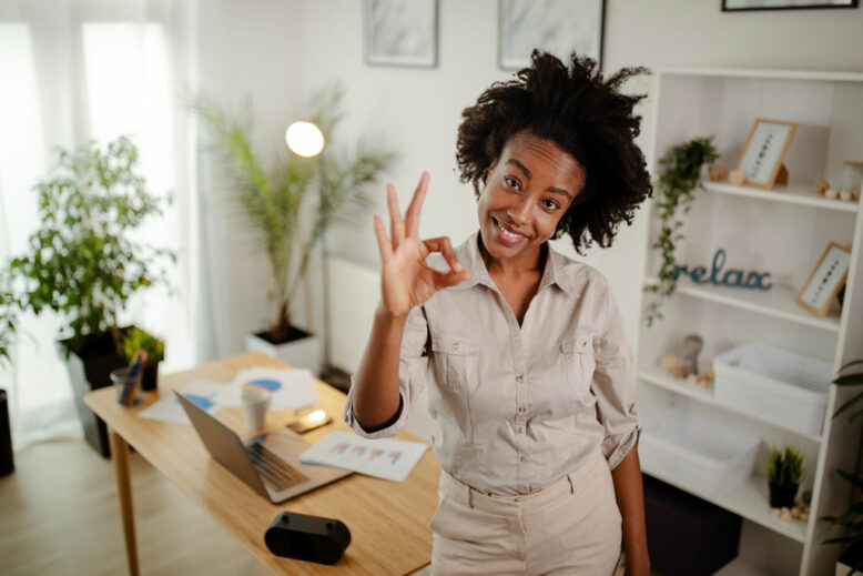 Black businesswoman looking at camera and gesturing OK with smile.