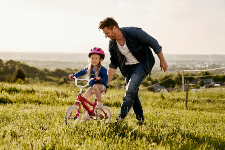 Man with toddler learning how to ride bike