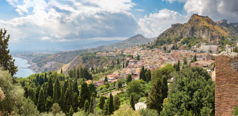 Panoramic view of Taormina with Giardini Naxox town in the background