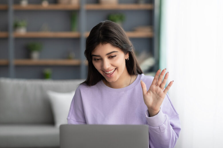 Online Meeting. Happy young woman using laptop computer for virtual conferencing, having video call at home. Cheerful millennial female communicating with colleagues, friends or psychologist remotely
