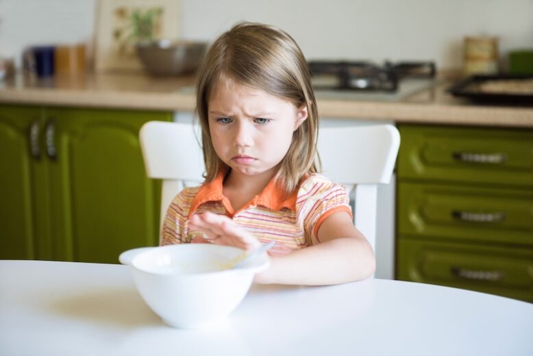 Cute little girl refuses to eat, pushes the plate