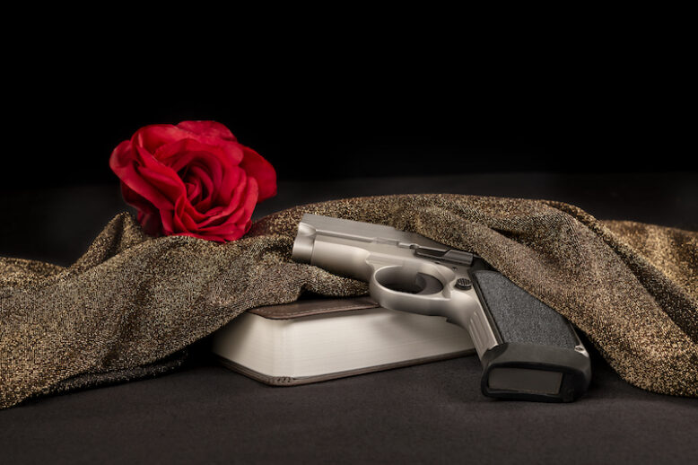 As part of a criminal organisation, this image represents a symbolic red rose behind a bible and gun, a pre-killing ritual of mafia hit men.
