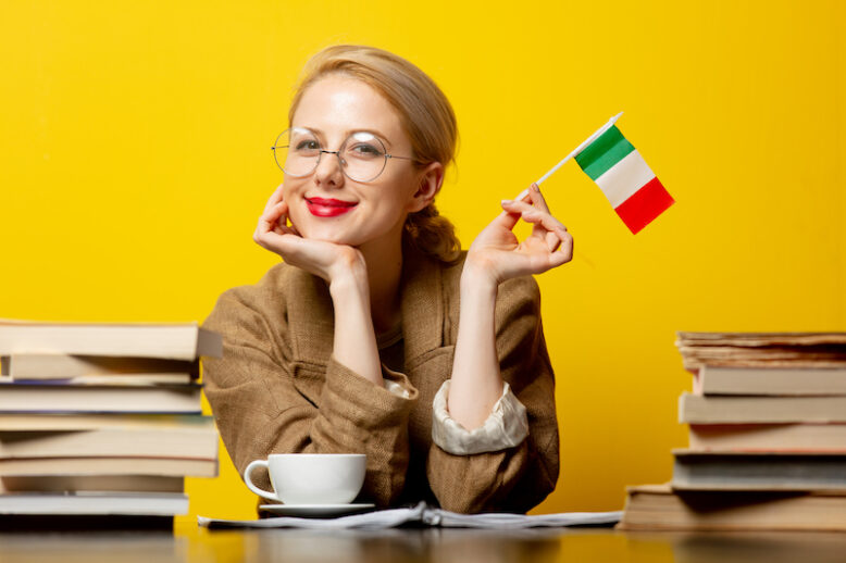 blonde woman with flag of Italy and books on yellow background