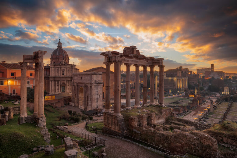 Rome, Italy at the historic Roman Forum ruins at dusk.
