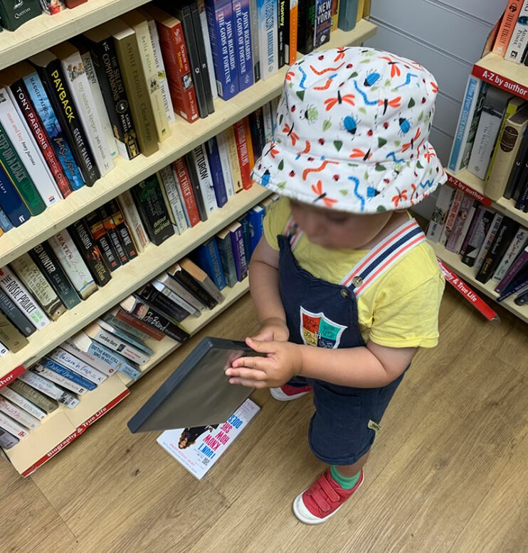 little boy looking at books in a bookstore
