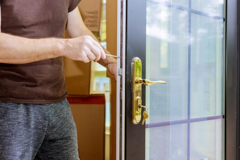 Carpenter fixing lock in door with home hand close-up.