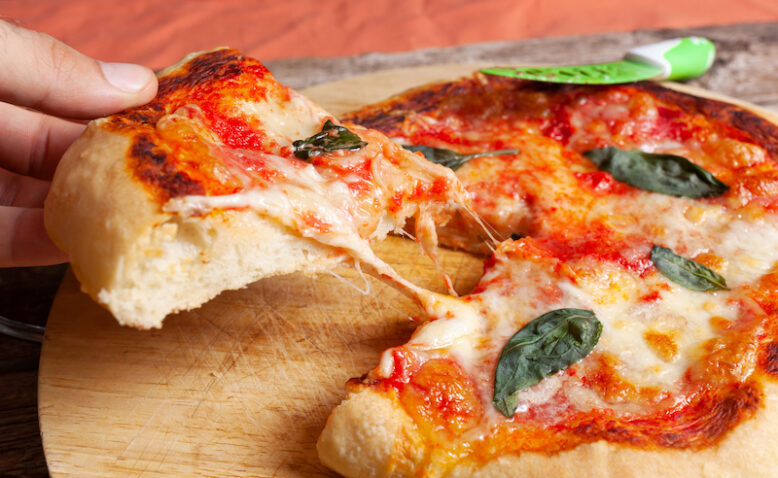 Fresh Homemade Italian Pizza Margherita with basil on rustic background.