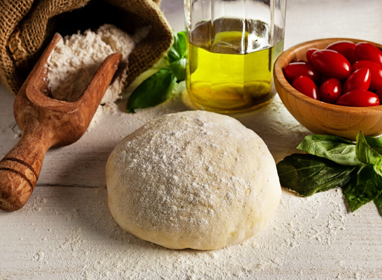 Ingredients for pizza. Dough, tomatoes, olive oil, basil. Italian cuisine.